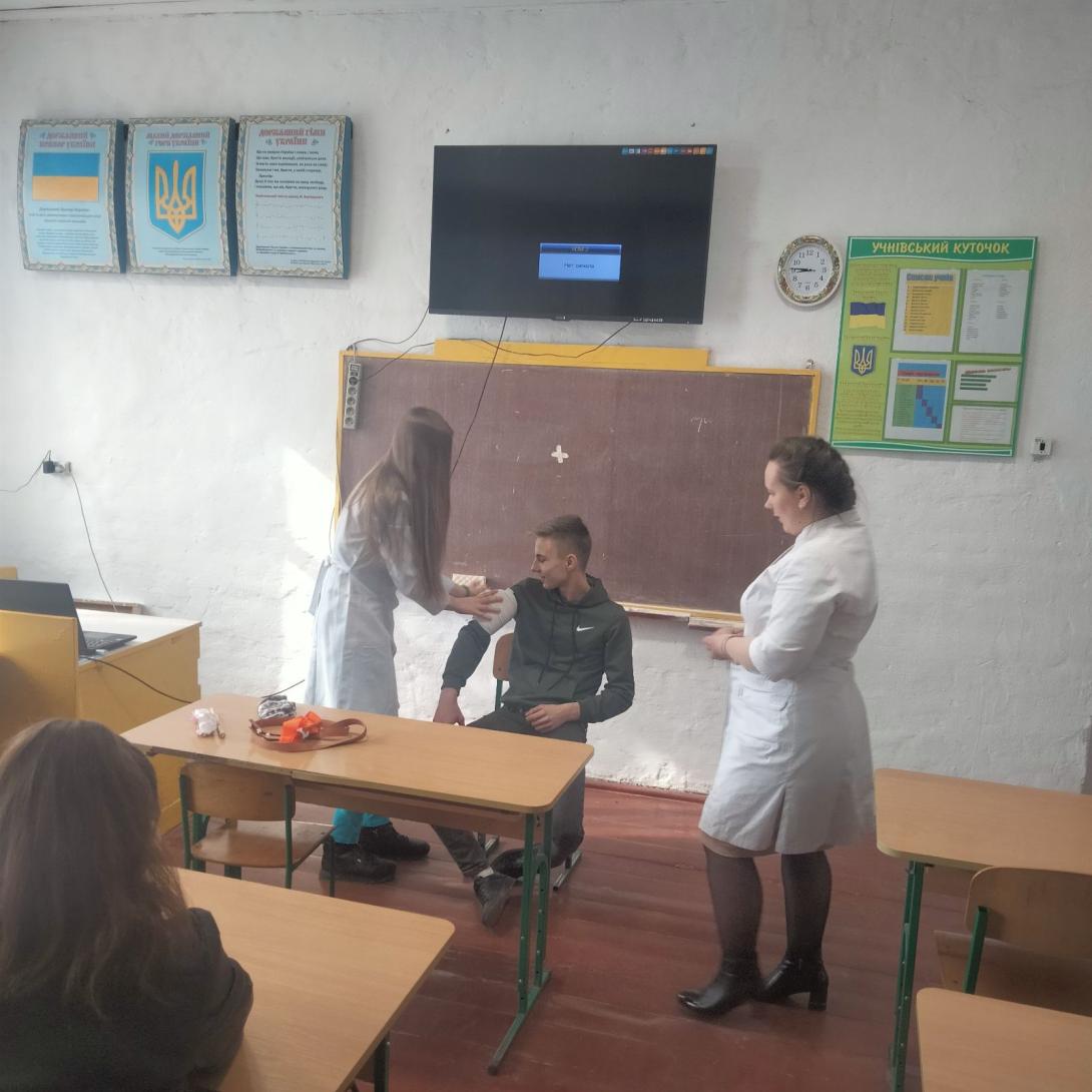 На уроці "Захист України" учні практикують свої знання з надання домедичної допомоги.